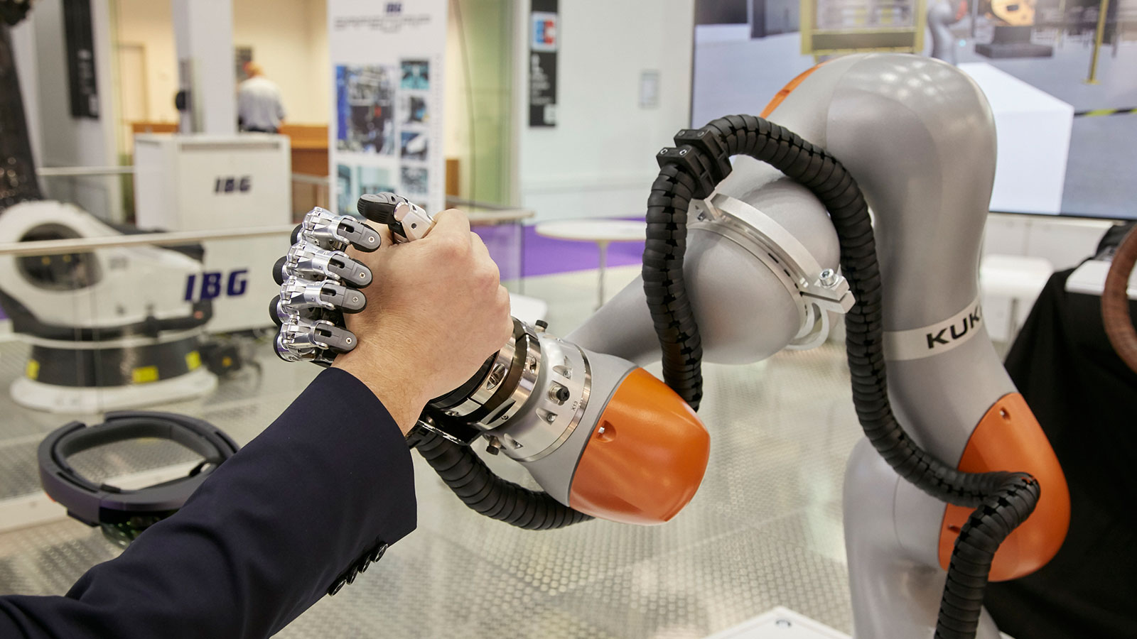 Armdrücken: Ein Roboter-Arm und ein Mensch auf der NORTEC